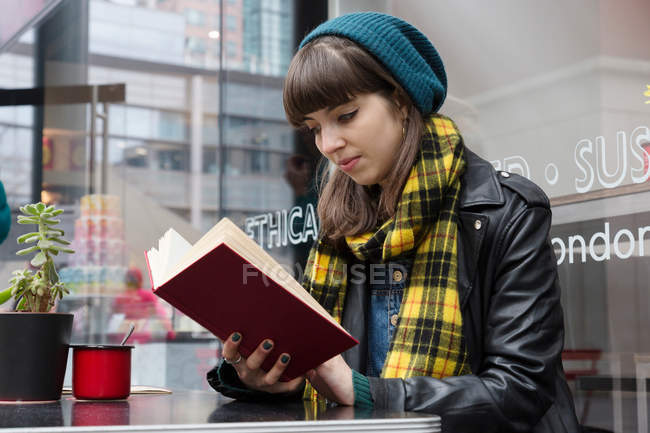 Mujer joven leyendo libro - foto de stock