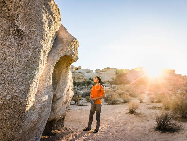 Männlicher Boulderer schaut zu Felsbrocken auf — Stockfoto