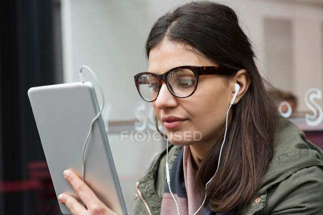 Junge Frau schaut auf digitales Tablet — Stockfoto