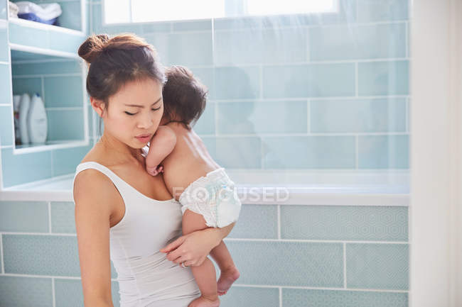 Woman carrying baby daughter — Stock Photo