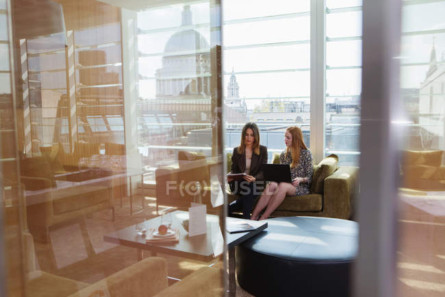 Reunión de empresarias en sofá de oficina - foto de stock