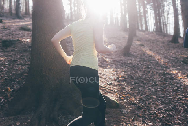 Бегущая женщина в крутом лесу — стоковое фото