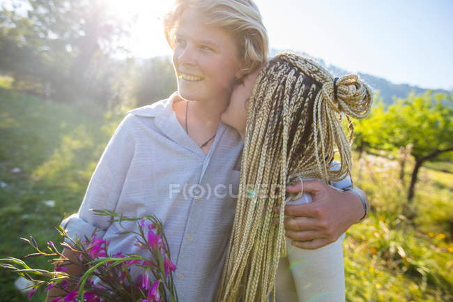 Paar mit Wildblumen im Feld — Stockfoto