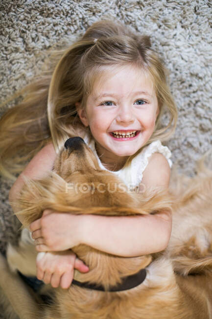 Portrait of young girl hugging pet dog — Stock Photo