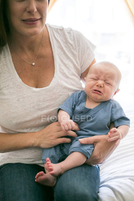 Mère assise avec bébé garçon pleurant — Photo de stock