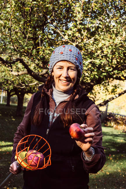 Mujer sosteniendo recolector de frutas - foto de stock