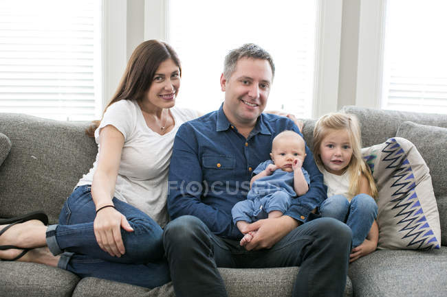Портрет семьи, сидящей на диване — стоковое фото
