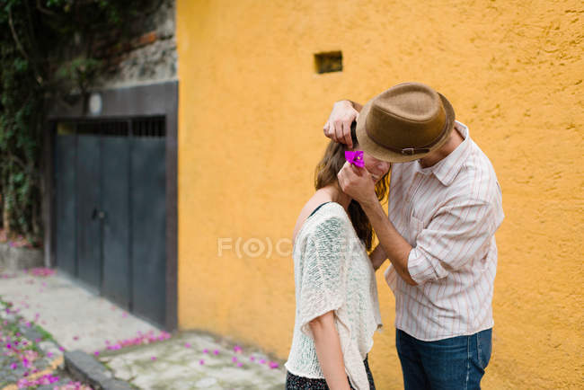 Uomo mettendo fiore nei capelli delle donne — Foto stock