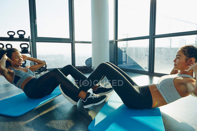 Duas mulheres jovens se exercitando no ginásio — Fotografia de Stock