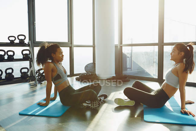 Two young women exercising in gym — Stock Photo