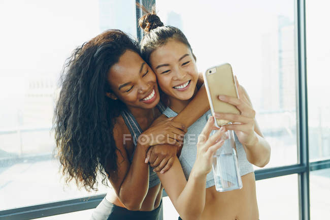 Due giovani donne in palestra, facendo selfie — Foto stock