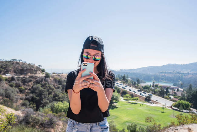 Молодая женщина фотографирует знак Голливуда — стоковое фото