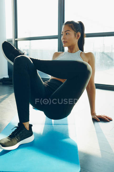 Mujer joven haciendo ejercicio en el gimnasio - foto de stock