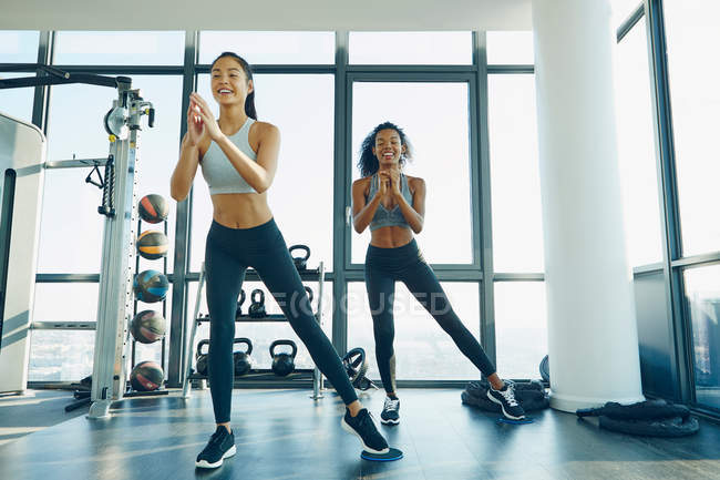 Dos mujeres jóvenes haciendo ejercicio en el gimnasio - foto de stock