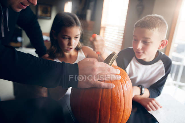 Father and children pumpkin carving — Stock Photo