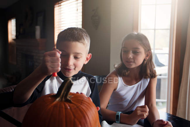 Children carving pumpkin at home — Stock Photo