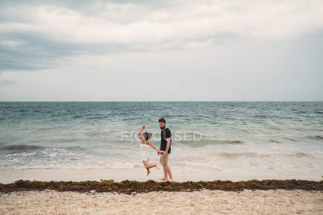 Padre e hija jugando en la playa - foto de stock