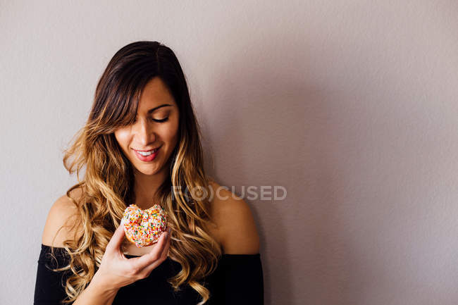 Young woman holding doughnut hole — Stock Photo