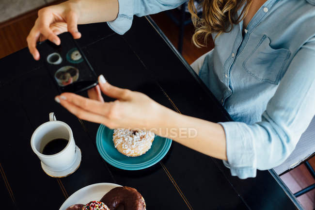 Mulher que fotografa donut — Fotografia de Stock