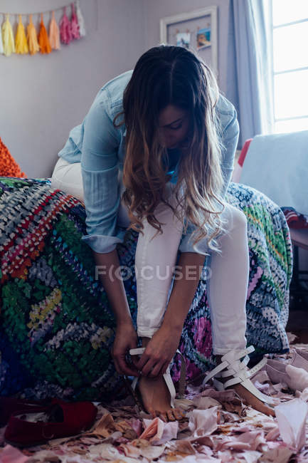 Junge Frau zieht Sandalen an — Stockfoto