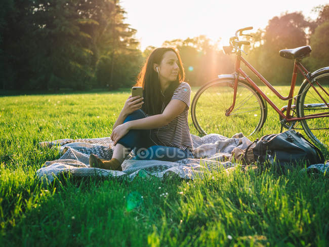 Frau benutzt Handy auf Gras — Stockfoto