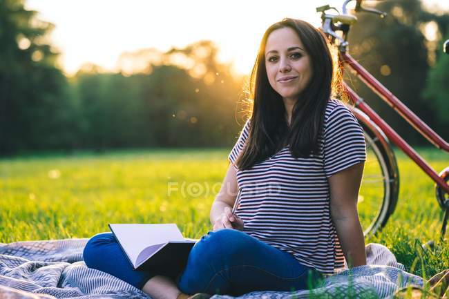 Woman reading book on grass — Stock Photo