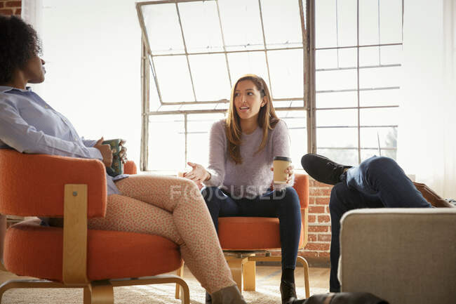 Трое коллег, сидящих вместе, обсуждают — стоковое фото