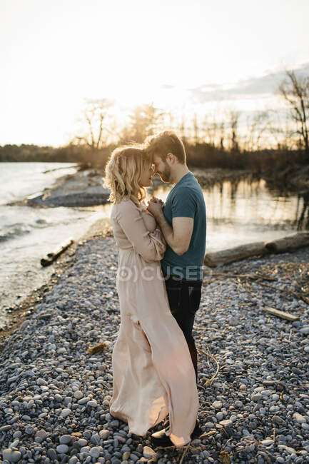 Couple au bord du lac, face à face, mains tendues — Photo de stock