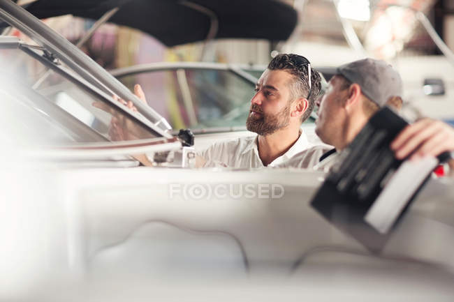 Two men checking windscreen on boat in repair workshop — Stock Photo