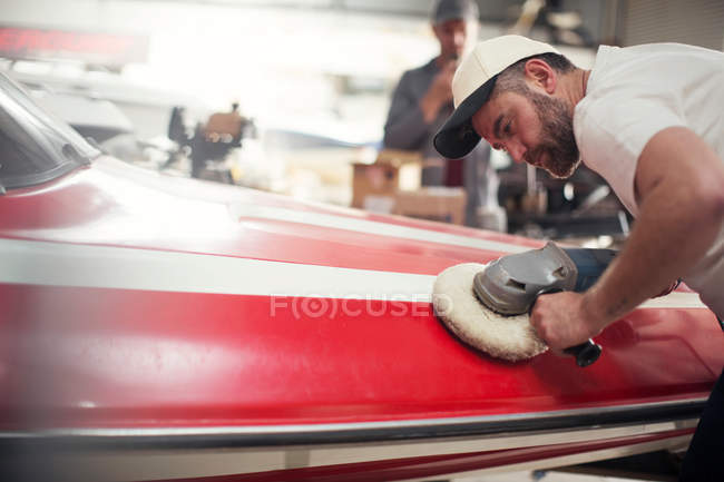 Hombre barco pulido en taller de reparación - foto de stock