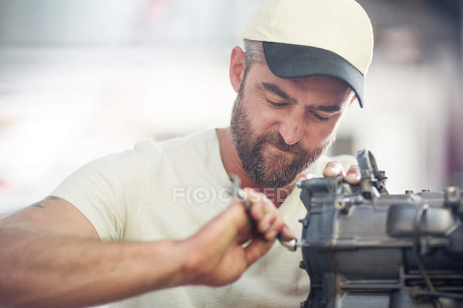 Homme réparant moteur hors-bord dans l'atelier de réparation de bateau — Photo de stock