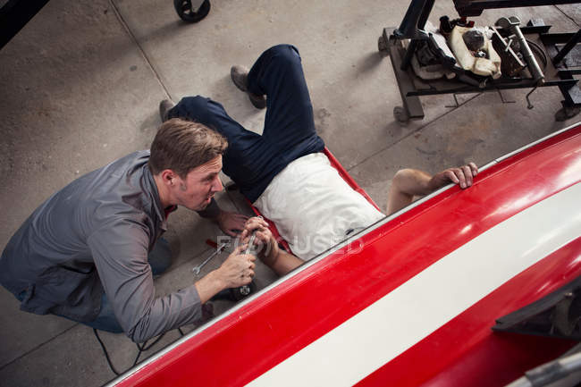Overhead view of two men repairing in boat repair workshop — Stock Photo