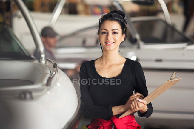 Портрет молодой женщины с планшетом в мастерской по ремонту лодок — стоковое фото
