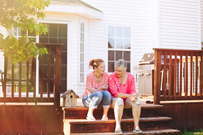 Mother and adult daughter sitting on porch — Stock Photo