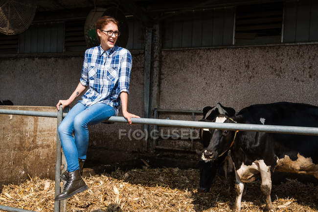 Женщина-фермер сидит на заборе — стоковое фото