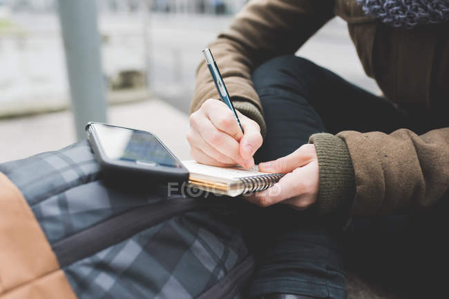 Femme écrivant dans un carnet — Photo de stock
