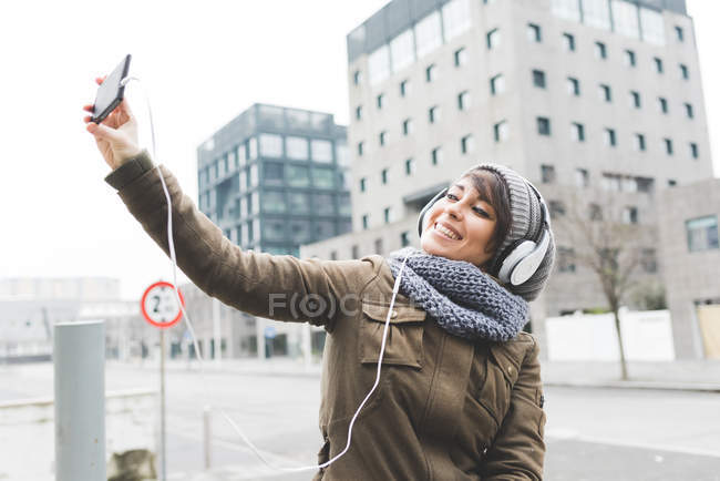Женщина делает селфи на смартфоне — стоковое фото