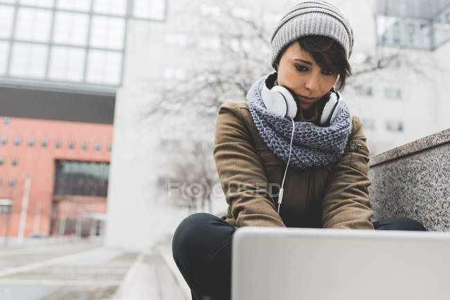Жінка друкує на ноутбуці в місті — стокове фото