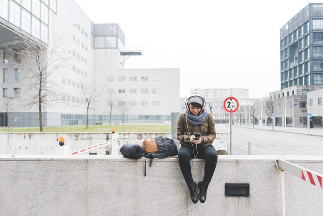 Женщина-турист сидит на стене — стоковое фото