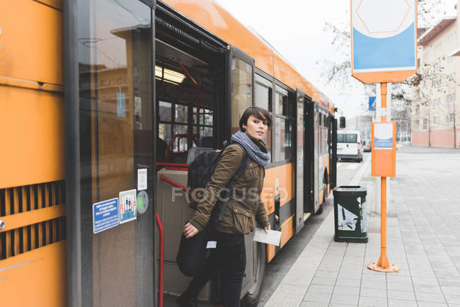 Female backpacker exiting bus — Stock Photo
