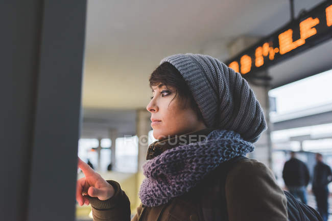Жінка в трикотажному капелюсі за допомогою сенсорного екрану — стокове фото