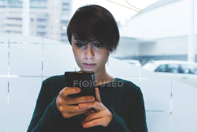 Frau schaut aufs Smartphone — Stockfoto