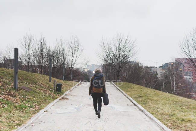 Backpacker walking alone in city park — Stock Photo