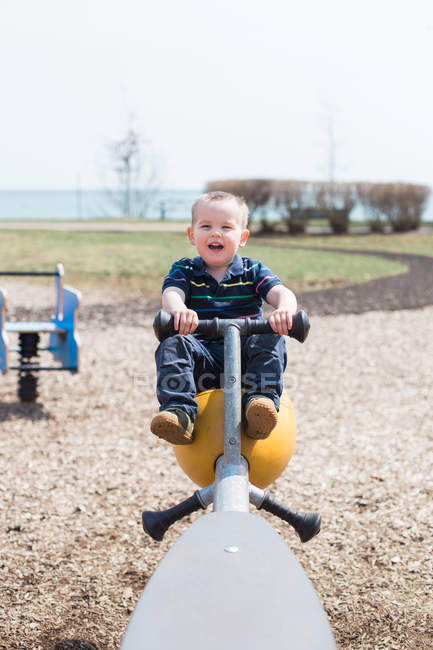 Toddler riding on seesaw — Stock Photo