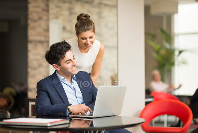 Uomo e donna d'affari che guardano il portatile — Foto stock