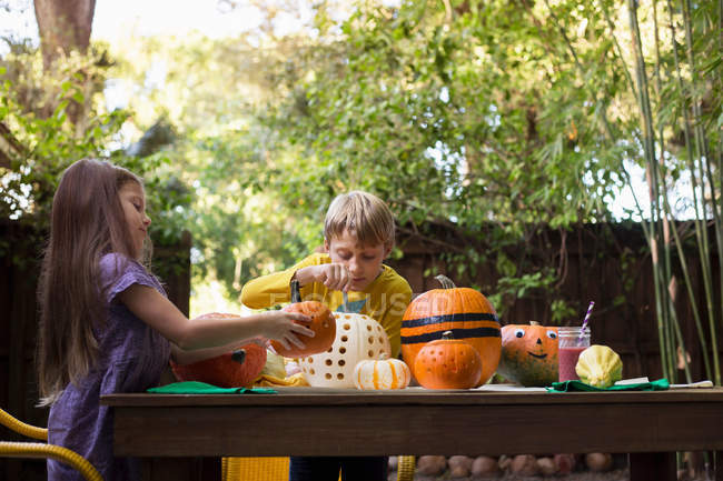 Boy and sister carving pumpkins — Stock Photo