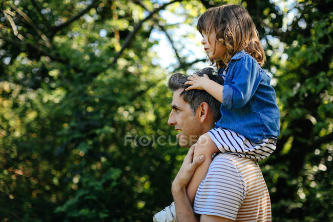 Padre piggybacking niña - foto de stock