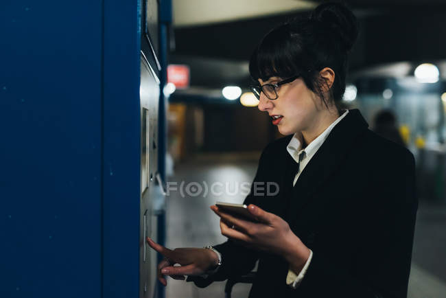 Businesswoman using ticket machine — Stock Photo