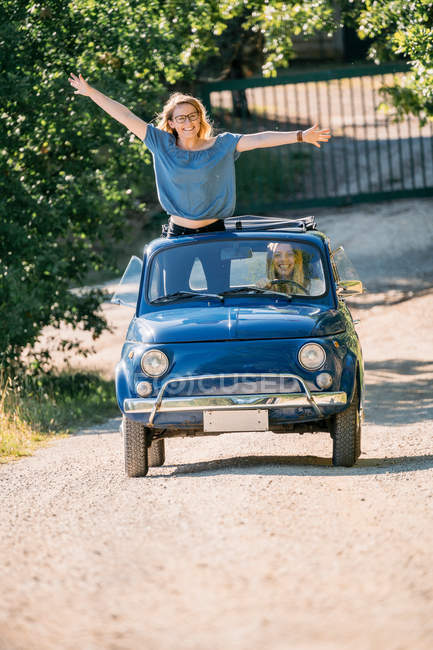 Mujeres jóvenes en coche descapotable vintage - foto de stock