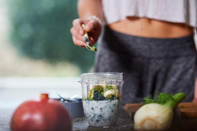 Young woman preparing smoothie — Stock Photo